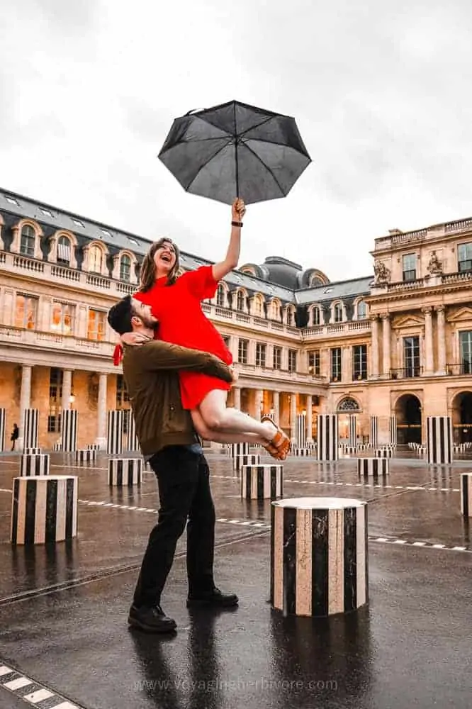 Smartphone travel photo of a man lifting woman in the air as she holds an open umbrella